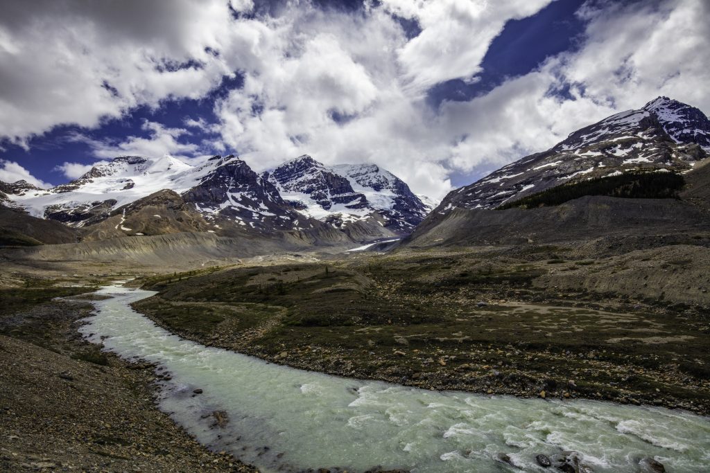 The blue-green waters of the Sunwapta river flow off to the lower right of the image with Mt Andromeda in the Background.