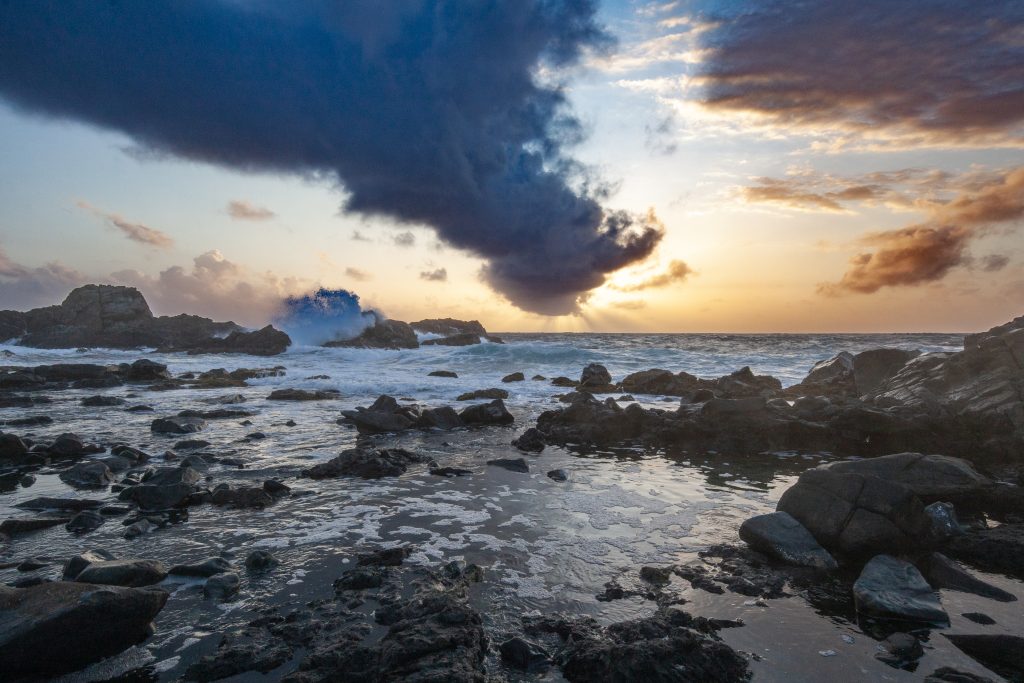 Waves crash over the rocks at sunrise on the Eastern Coast of Aruba in Arikok National Park